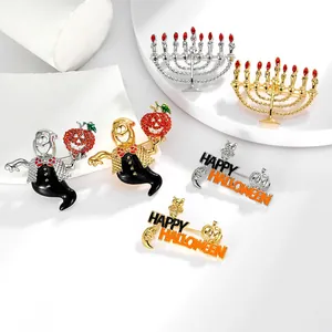 Detail von Halloween-Geist-Pins und Menora-Broschen mit Strassbesatz auf weißem Sockel