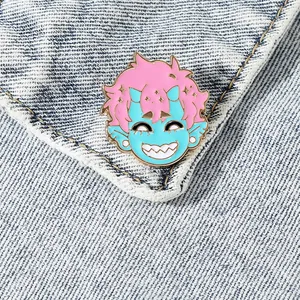 Pin's en émail démon aux cheveux roses avec bord doré sur une veste en jean bleu clair
