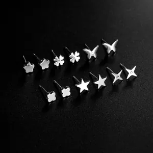 Vista macro de 7 pares de pendientes plateados con forma de corazón y estrella en negro