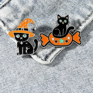 Halloween black cat and pumpkin candy enamel brooch set on blue denim fabric