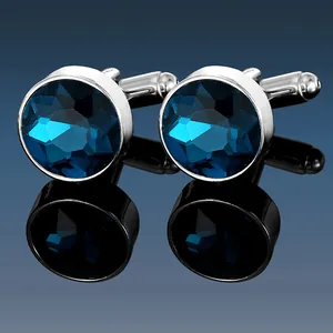 Macro shot of men's silver cufflinks with round multi-faceted deep blue crystal stones