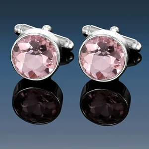 Detailed macro view of silver metal cufflinks with faceted pink crystal stones and reflections