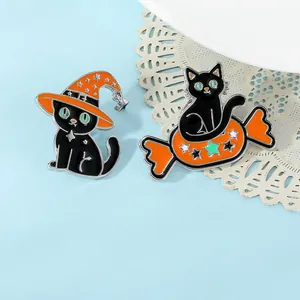 Detail of Halloween black cat enamel pins featuring a wizard hat and orange candy on blue background