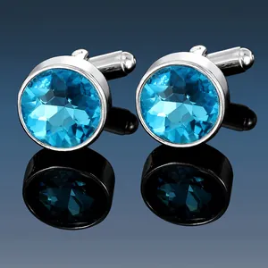 Close-up of men's silver cufflinks with multifaceted dark blue round crystal stones