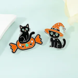 Detail of two Halloween enamel pins featuring a black cat with candy and a witch hat