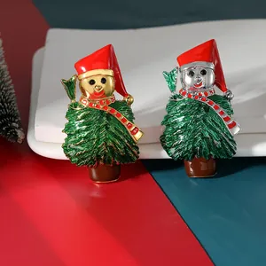 Close-up of gold and silver enamel Christmas tree brooches on a festive pedestal
