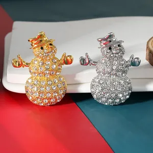 Close-up of sparkling gold and silver snowman brooches with rhinestone crystals