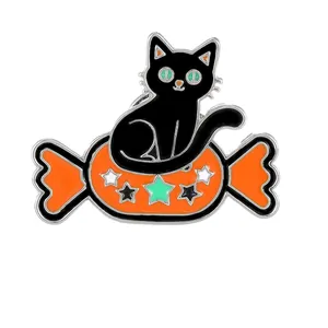Halloween black cat and orange candy enamel pin badge with star detail on white background