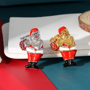 Macro detail of Santa Claus brooches with enamel finish and red rhinestone gift bags