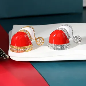 Detailed macro view of festive red enamel Christmas hat brooches with sparkling crystals