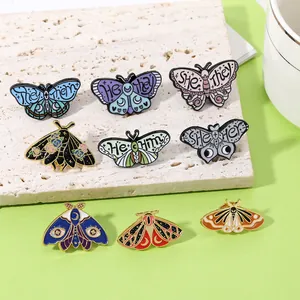 Detail view of colorful butterfly enamel pins with social pronouns and metallic finish