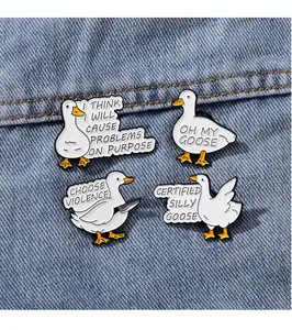 Close-up of funny cartoon duck enamel pins with humorous quotes on blue denim fabric