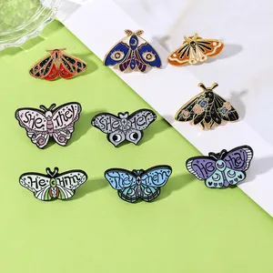 Detail of colorful moth and butterfly enamel pins featuring various personal pronouns