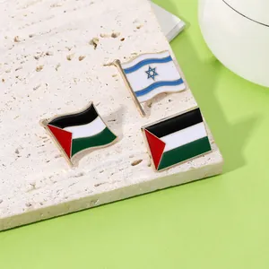 Detalle de los pines esmaltados de las banderas de Palestina e Israel sobre piedra