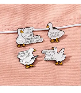 Close-up of four white enamel duck pins with humorous quotes on a pink fabric background