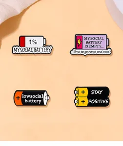Detailed view of four enamel battery pins with social battery phrases on orange background