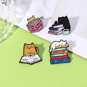 Detail of four colorful cat enamel pins featuring books and coffee on a green background