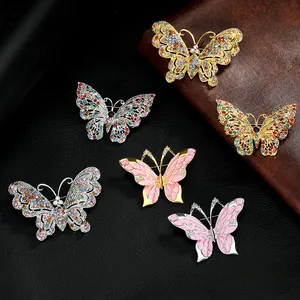 Macro-opname van kleurrijke emaille vlinderbroches met strassteentjes op een leren achtergrond