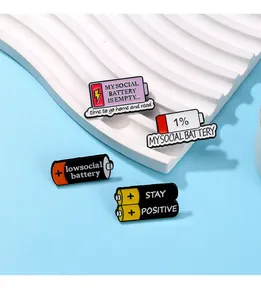 Macro detail of four creative enamel social battery pins displayed on a white stand