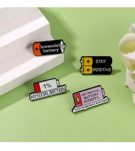 Detailed view of social battery enamel pins in various vibrant colors on a clean display