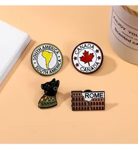 Detail view of colorful enamel pins featuring South America, Canada, Rome, and Egyptian cat
