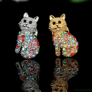 Funkelnde Katzenbrosche mit bunten Strasssteinen in Gold und Silber auf schwarzem Hintergrund