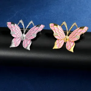 Detailopname van roze emaille vlinderbroches met zirkonia in zilveren en gouden uitvoering