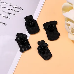 Pack of 4 black enamel pin backs with butterfly clutches and textured metal surface