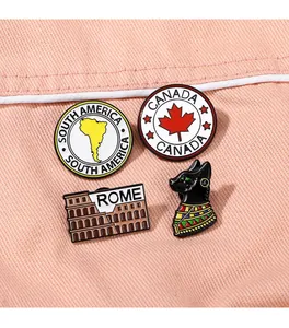 Detail view of enamel pins featuring Canada maple leaf and Rome colosseum on denim