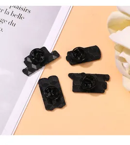 Detailed view of four black metal butterfly clutch pin backs on a pink decorative background