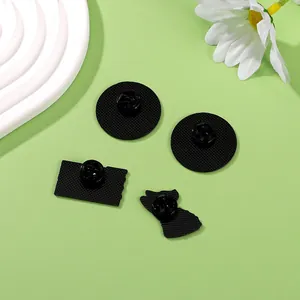Set of four black enamel badges showing back details with butterfly clutch pins