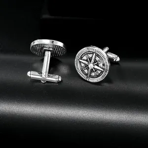 Detailed macro shot of vintage silver compass cufflinks with a sparkling zircon center