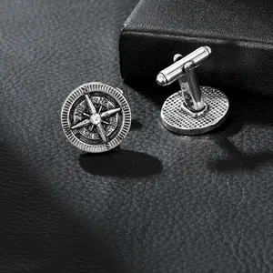 Macro view of vintage silver compass cufflinks with small diamond on black leather
