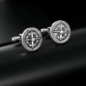 Detailed close-up of retro silver compass cufflinks with an eight-pointed star and zircon