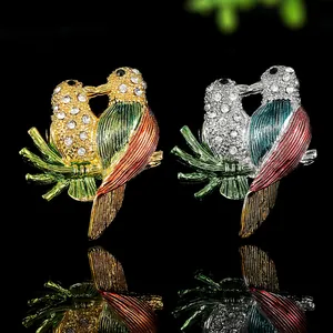 Vue détaillée de broches oiseaux avec émail coloré et strass brillants sur fond noir