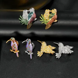 Détail de broches colibris avec émail coloré et strass brillants sur fond noir