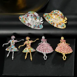 Macro detail of alloy brooches with dancing girl and hat designs set with sparkly rhinestones