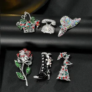 Detailed set of six enamel brooches including flowers, boots, and hats on black leather