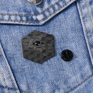 Zwarte zeshoekige emaille speld met geometrische 3D-textuur op blauwe denim stof