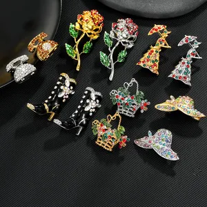 Macro view of crystal-encrusted brooches featuring boots and hats on black texture