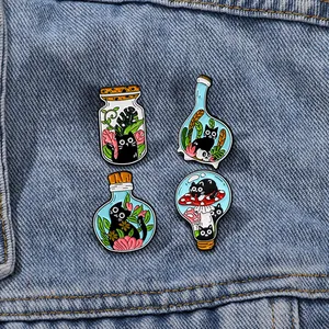 Lot de quatre broches chat noir dans des bocaux en verre sur veste en jean