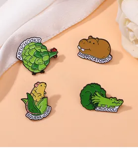 Detail of four creative enamel pins with animal and vegetable fusion puns on silk