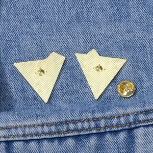 Golden triangle enamel pin backs with butterfly clutch on denim background