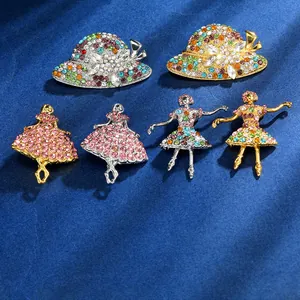 Macro shot of assorted crystal ballerina and hat brooches on a dark blue velvet background