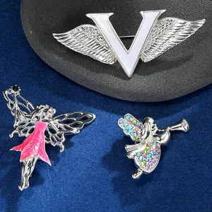 Detailopname van vlinder en engel broches met emaille en kleurrijke strasstenen op fluweel