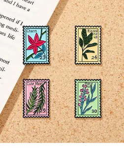 Set of four pastel enamel stamp pins featuring floral motifs and artistic lettering