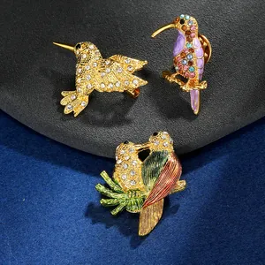 Détail de broches oiseaux colorées avec émail vif et cristaux étincelants