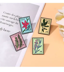 Detail view of four floral enamel stamp brooches on a vintage magazine page background