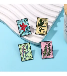 Close-up of four flower-themed enamel stamp pins with artistic botanical patterns