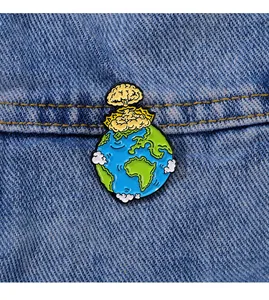 Détail d'un pin's en émail terre et champignon atomique sur tissu denim bleu